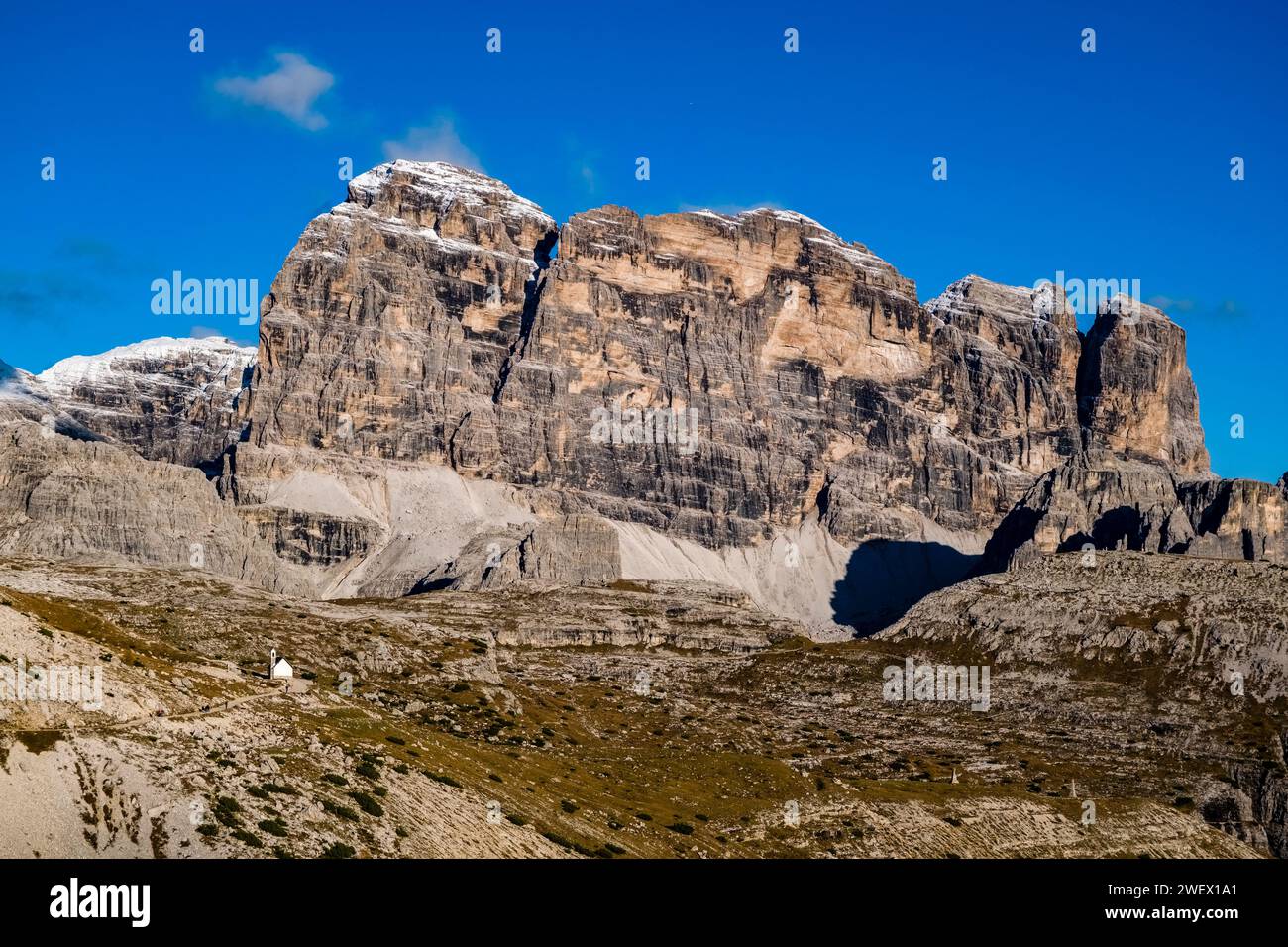 The rocky summits of the rock formation Croda dei Toni in Tre Cime National Park, partially covered in fresh snow in autumn. Stock Photo