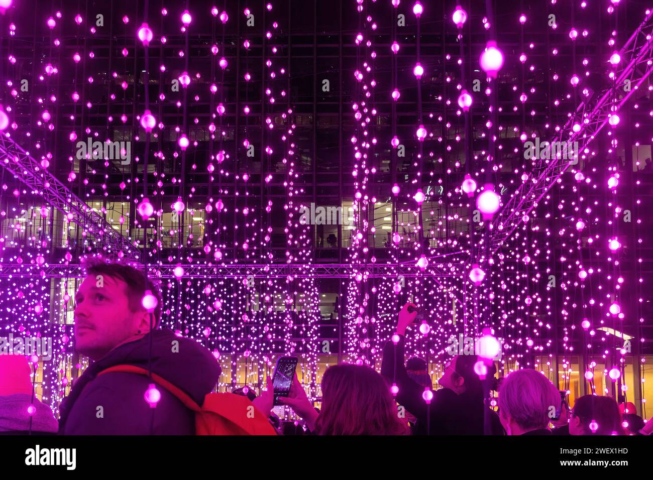 Canary Wharf Winter Lights, 26th January 2024, The popular annual Canary Wharf Winter Lights Festival is taking part in London from 17th to 27th January 2024, with 13 colourful light installations to see. Pictured: people enjoying the immersive art experience called Submergence by Squidsoup in Montgomery Square Stock Photo