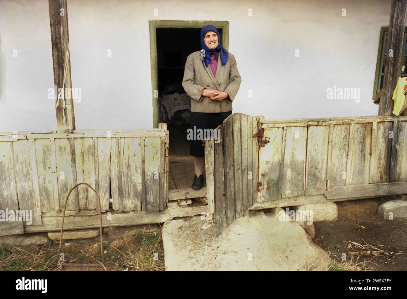 Vrancea County, Romania, approx. 1992. Woman in the porch of her simple traditional house. Stock Photo