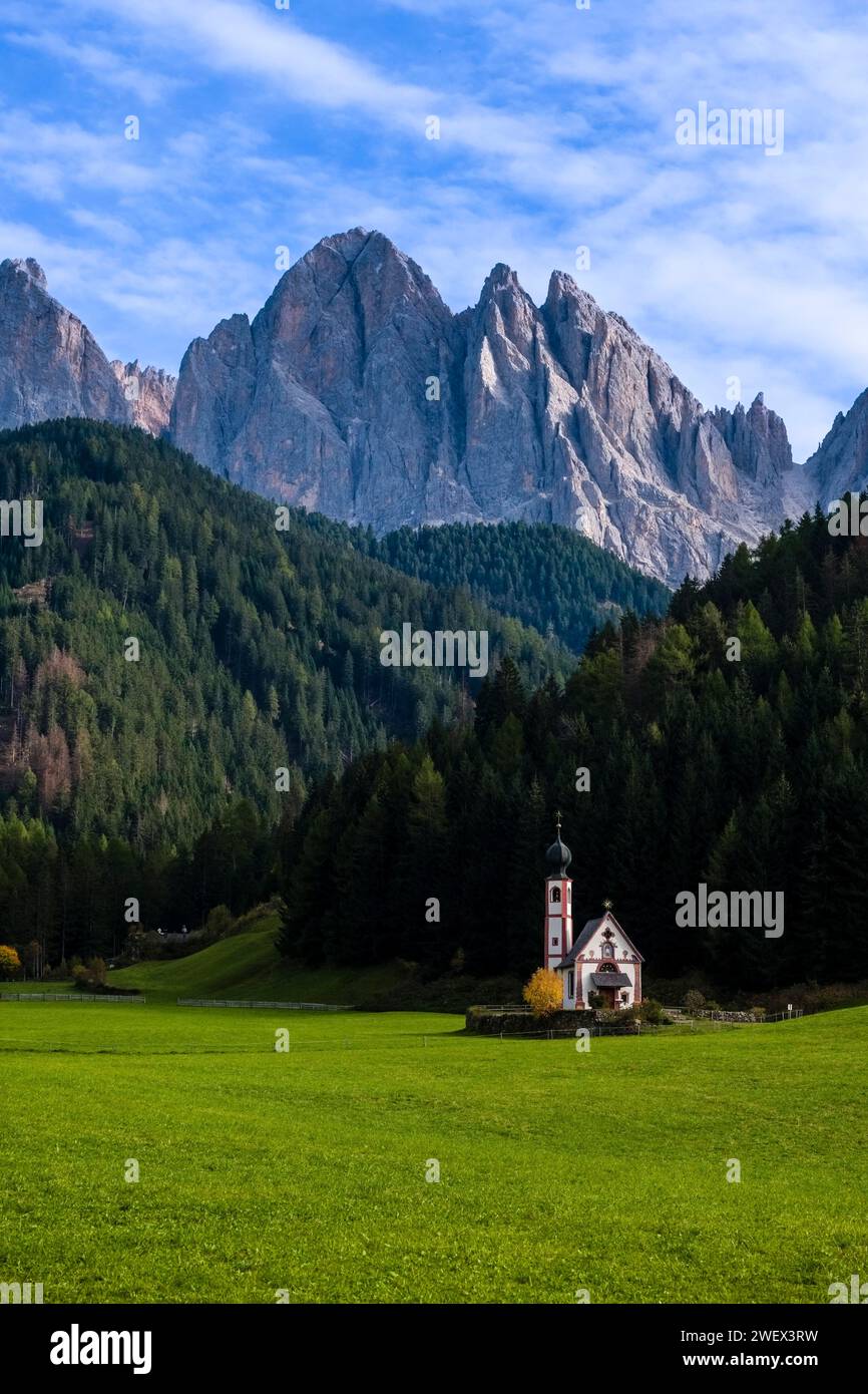 View of the chapel of St. John in Ranui in St. Magdalena in the Villnöss Valley in autumn, north faces and summits of Odle group in the distance. Bolz Stock Photo