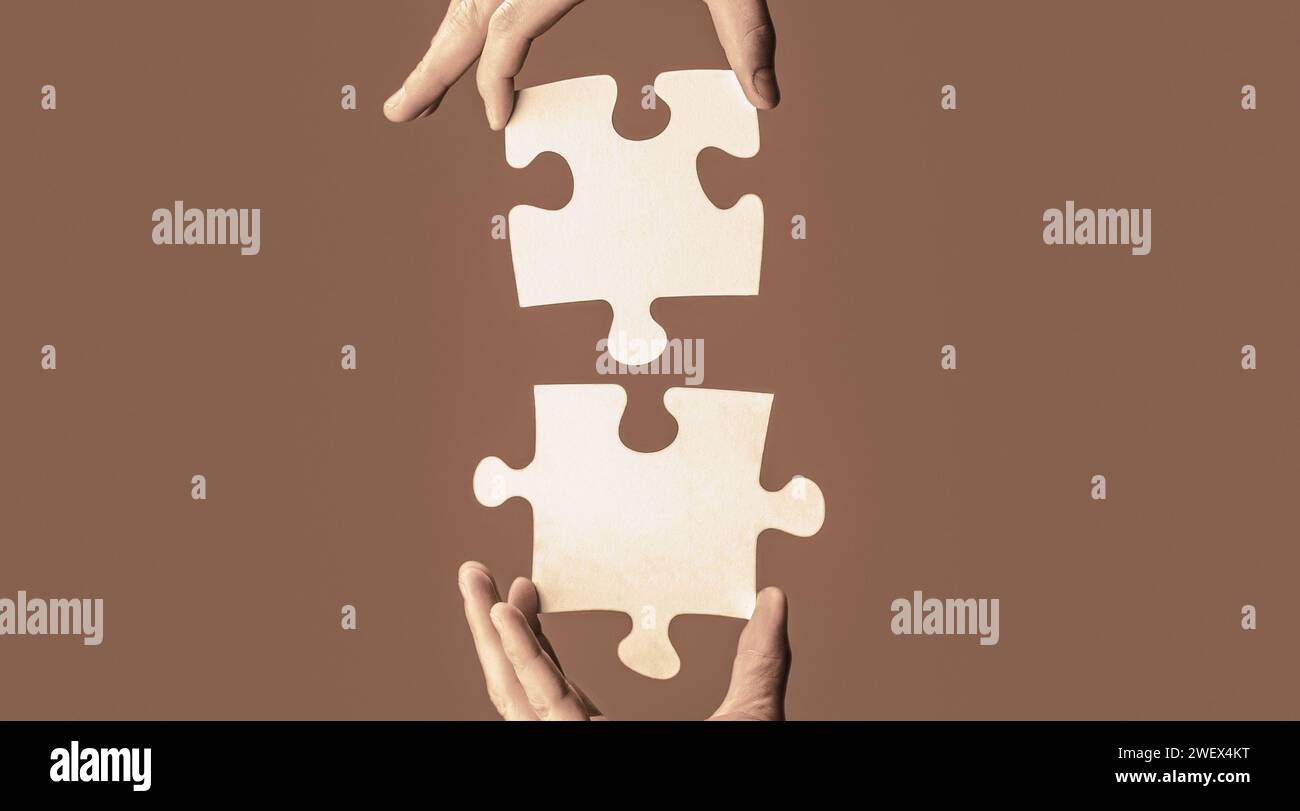 Closeup hands of man connecting jigsaw puzzle. Two hands trying to ...