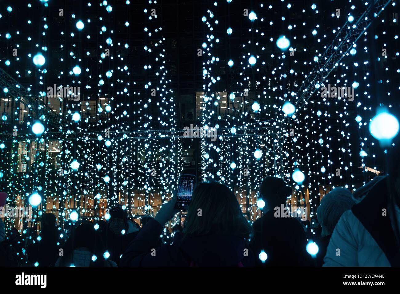 Canary Wharf Winter Lights, 26th January 2024, The popular annual Canary Wharf Winter Lights Festival is taking part in London from 17th to 27th January 2024, with 13 colourful light installations to see. Pictured: people enjoying the immersive art experience called Submergence by Squidsoup in Montgomery Square Stock Photo
