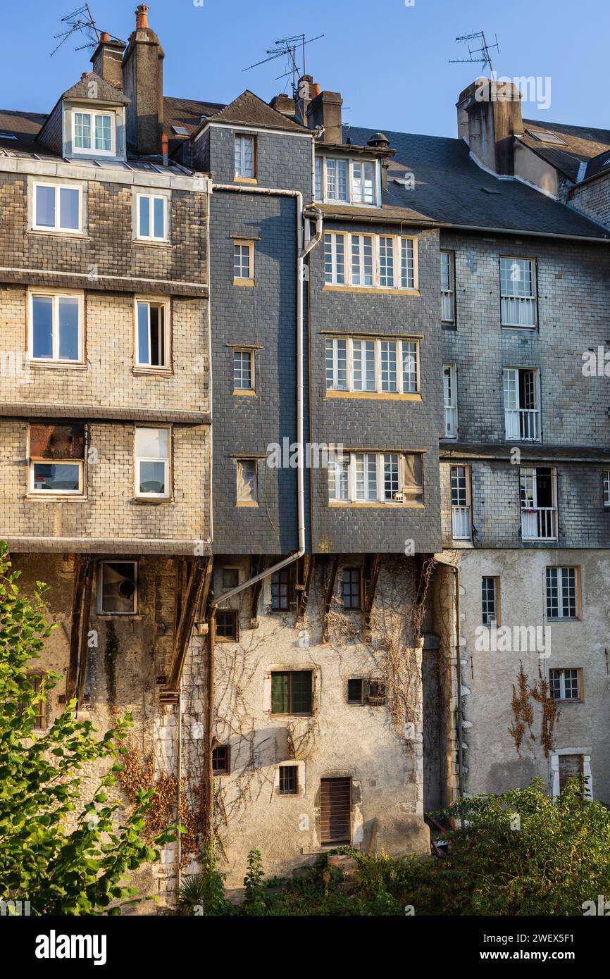 Traditional multistory slatecovered old houses with tiled roofs, entwined with ivy. Pau