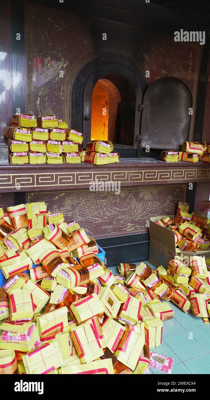 Cultural Traditions: during the festive Lunar New Year, stacks of golden spirit money await ritualistic burning. Stock Photo