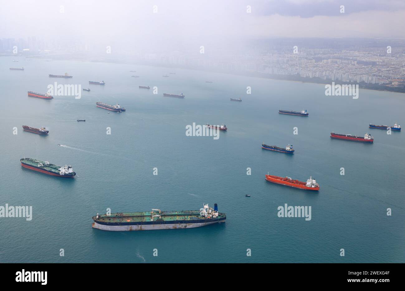 Aerial view of the Singapore Strait, Ocean liner, tanker and Cargo Ship with rainstorm in Singapore Strait, View from plane. Stock Photo