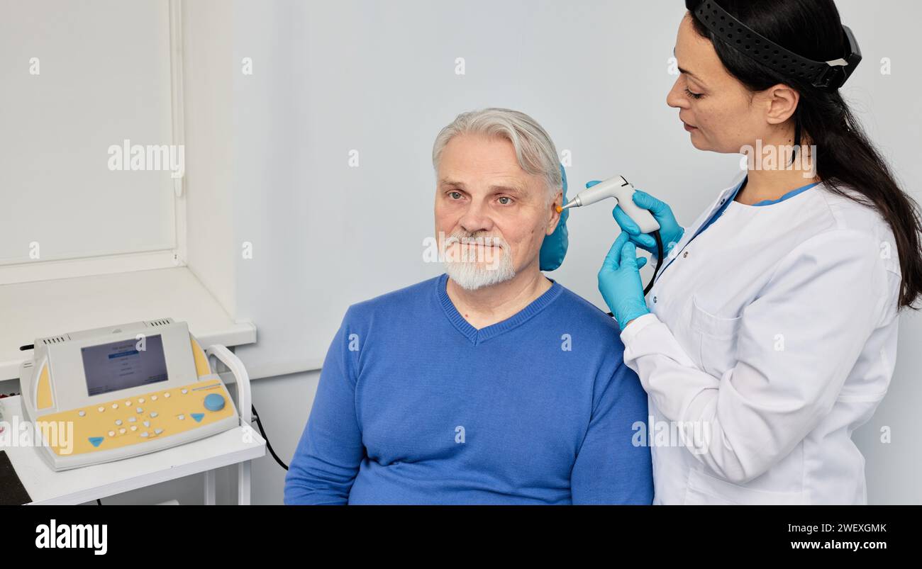 Experienced audiologist with tympanometer probe doing tympanometry