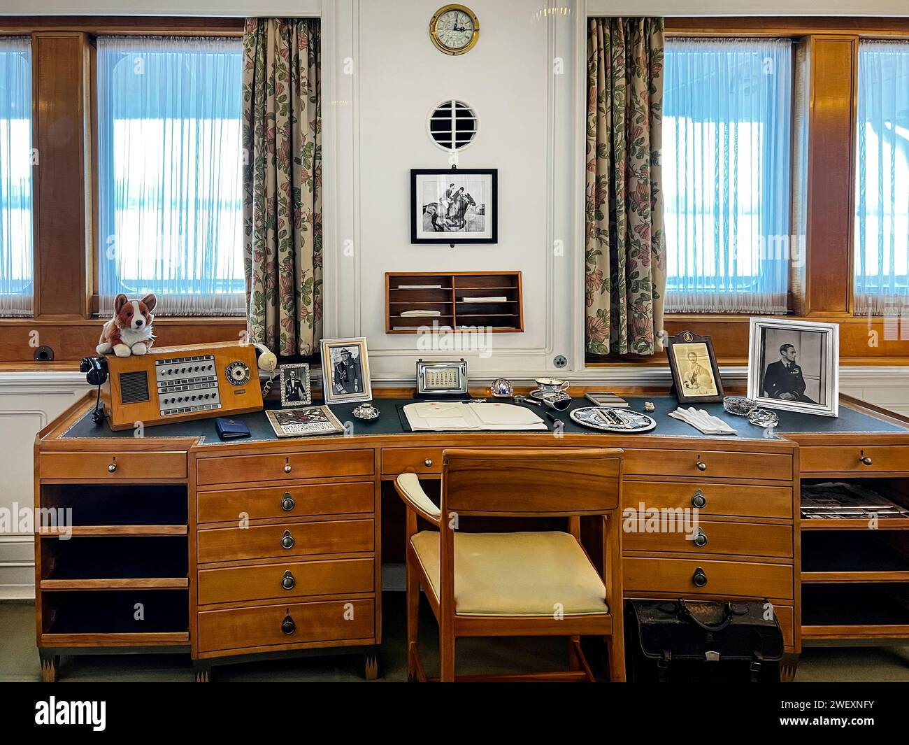 Queen Elizabeth's Office Desk  With Corgi Stuffed Dog, Framed Photos and Telephone Onboard Her Majesty's Yacht Britannia Stock Photo