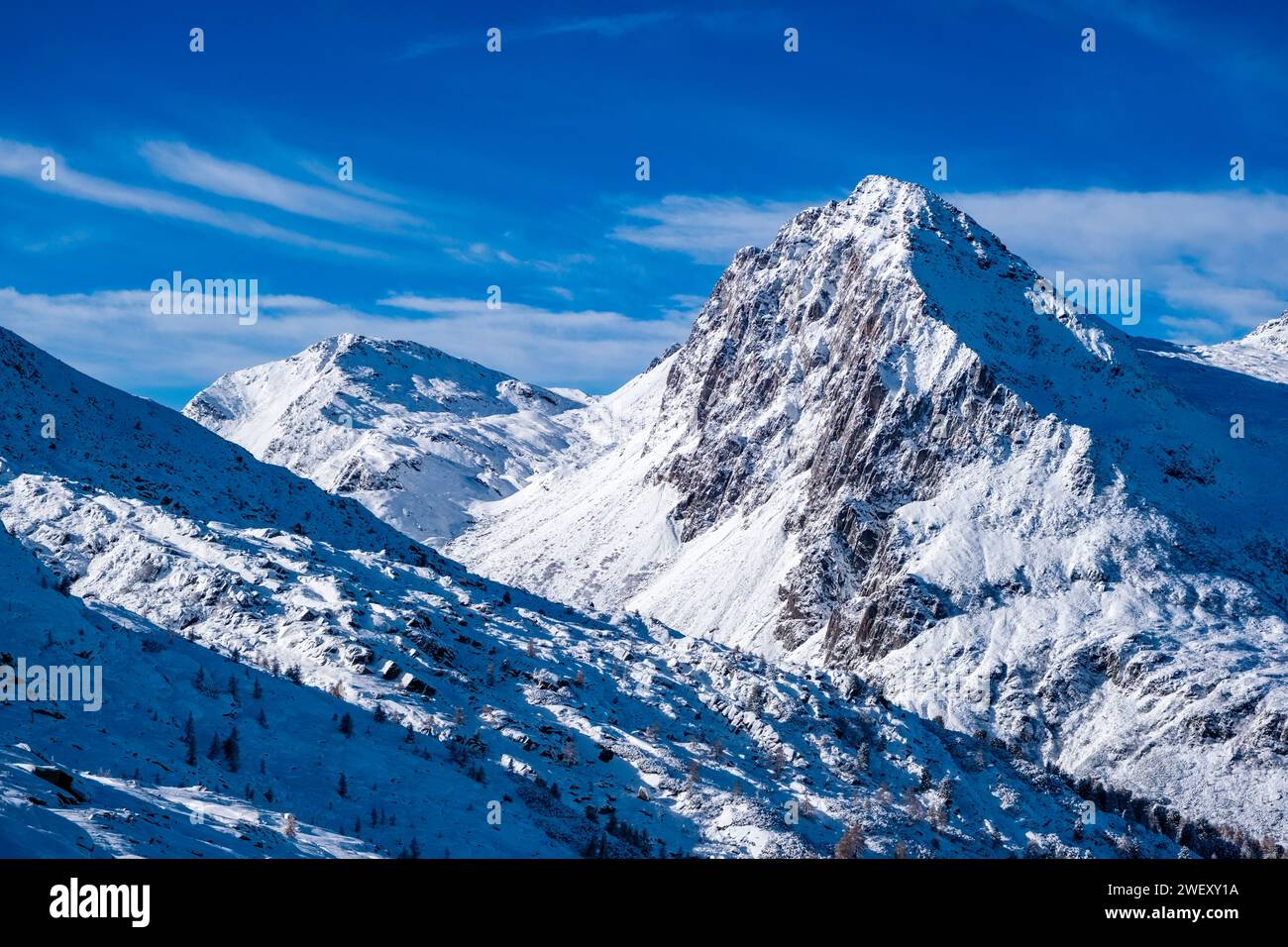 The snow-covered summits of Cima Val Cigolera and Colbricon Ovest, seen from the summit of Tognazza in winter. Stock Photo