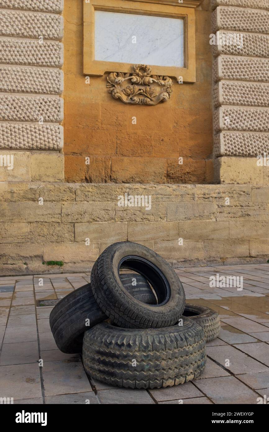 Montpellier, France, 2024. A few tyres escaped the fires lit by angry farmers protesting falling incomes in front of the arch of triumph (vertical) Stock Photo