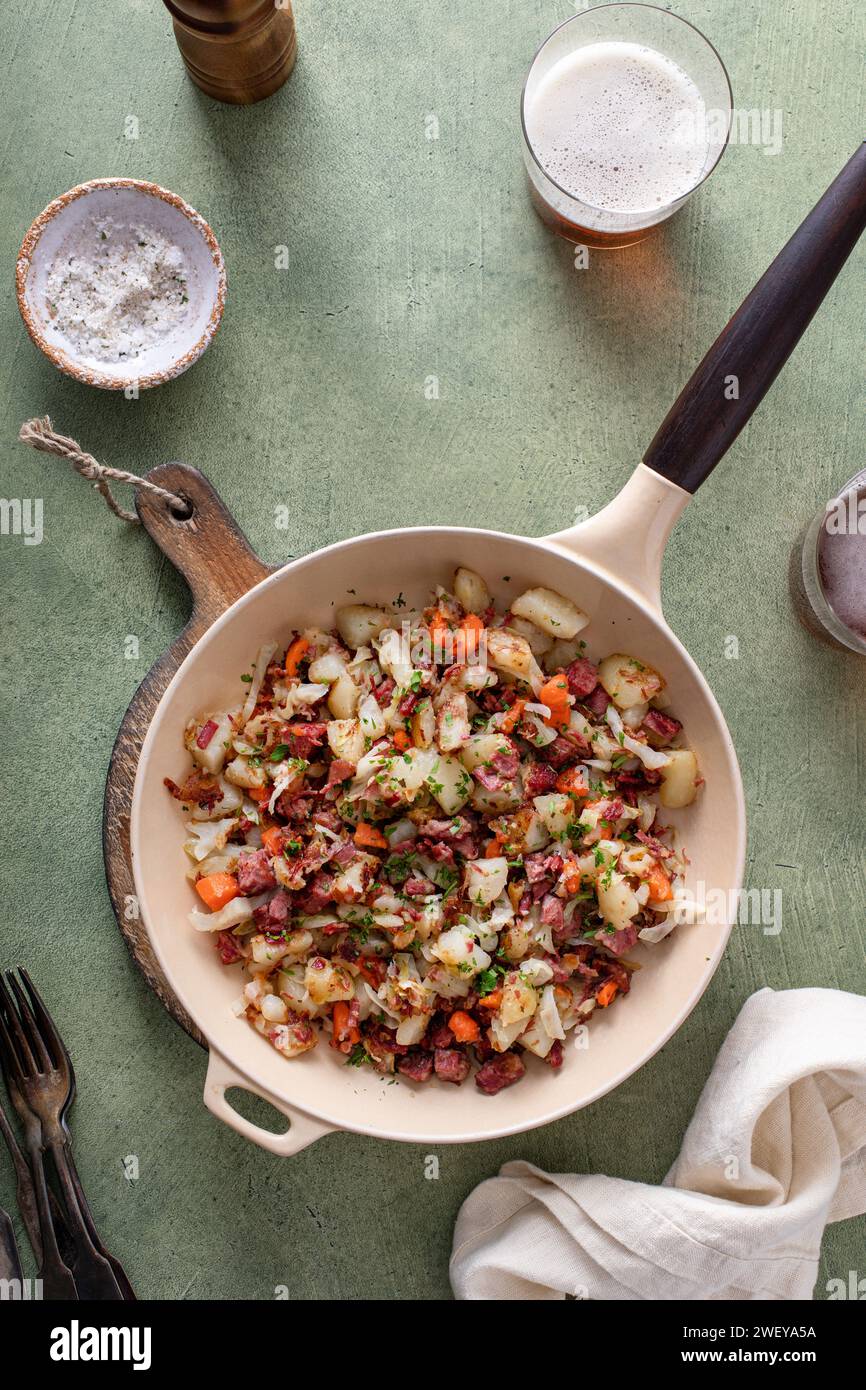 Corned beef hash with potatoes, cabbage and carrots in a cast iron pan