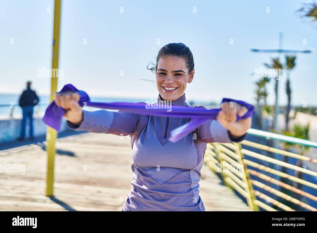 Portrait of confident sportswoman stretching elastic band with