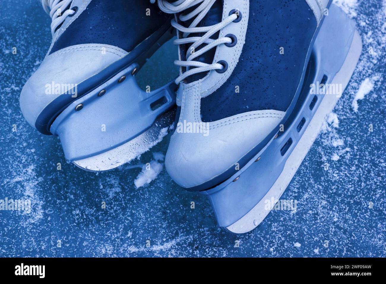 The Ice Skating Shoes For Winter Sport. Pair Of Ice Skates On Frozen Rink, Closeup View. Stock Photo