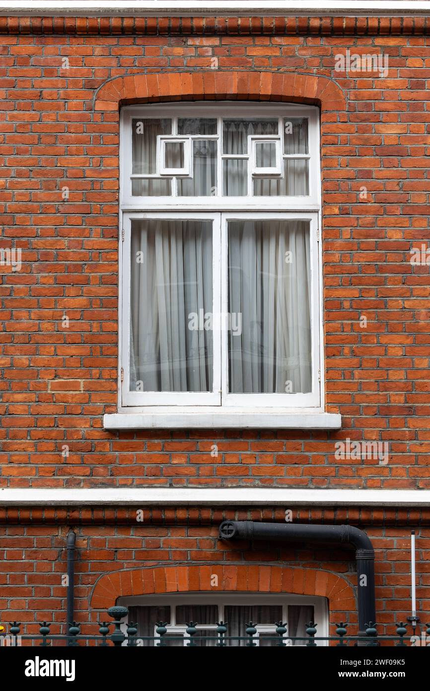 classic white windows of typical london architecture with red brick wall Stock Photo