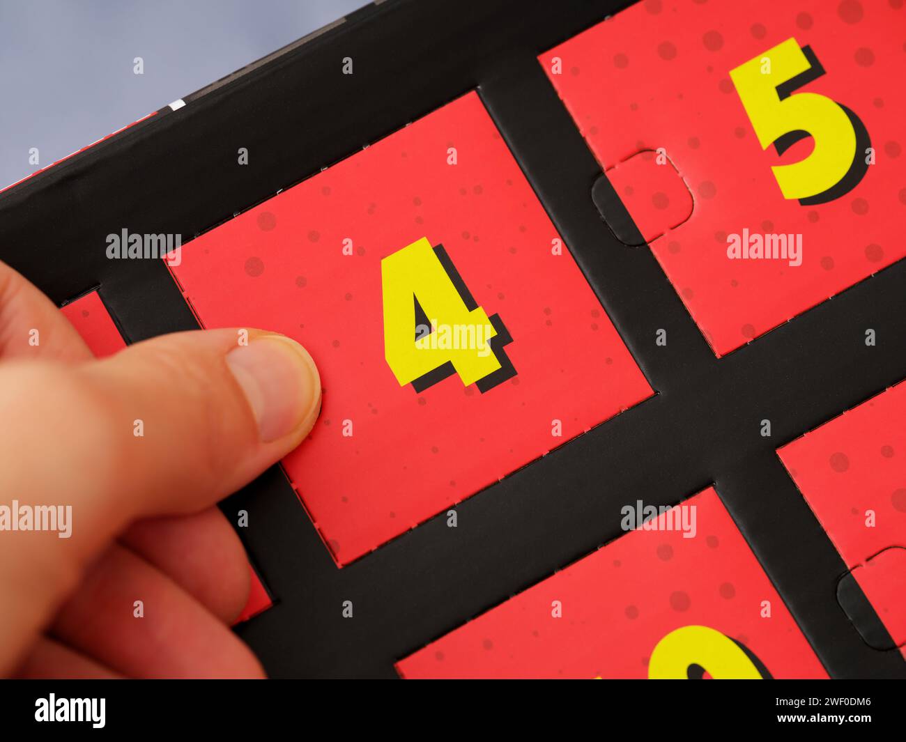 A woman hand opening a door with number 4 on an advent calendar Stock A woman hand opening a door with number 4 on an advent calendar Stock