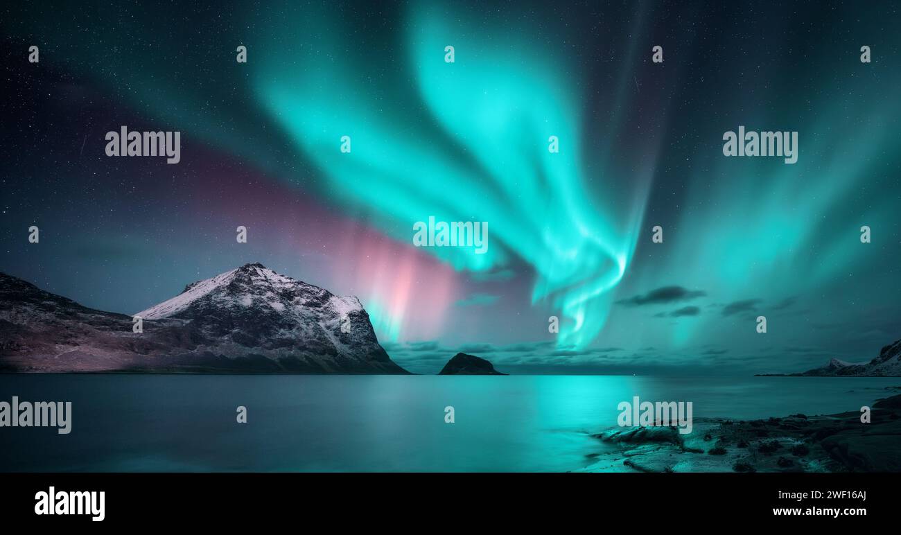 Northern Lights over the sea, snowy mountains at starry night Stock ...