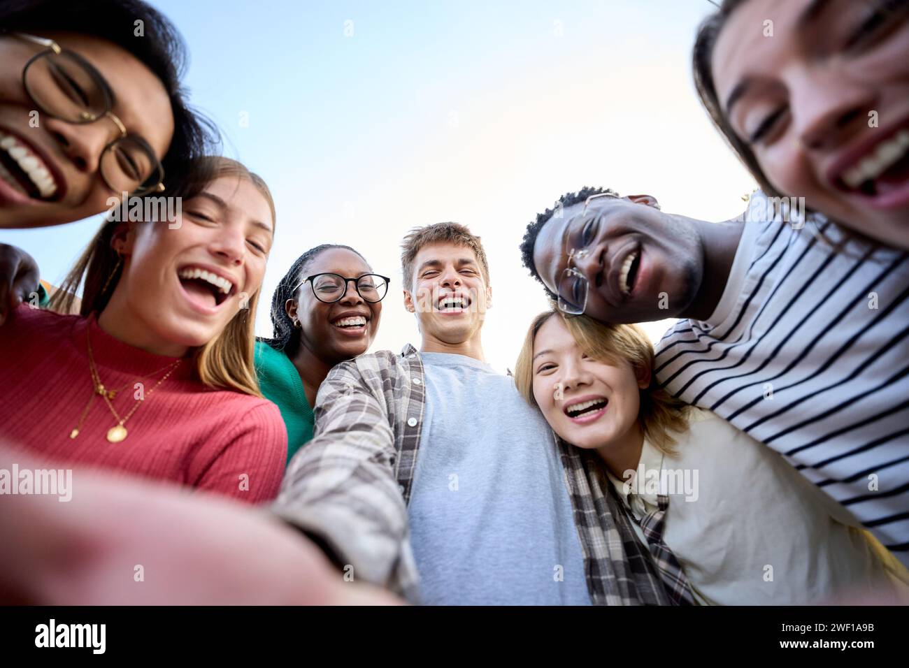 Portrait large group multiracial friends posing smiling and looking to camera. Happy young people Stock Photo