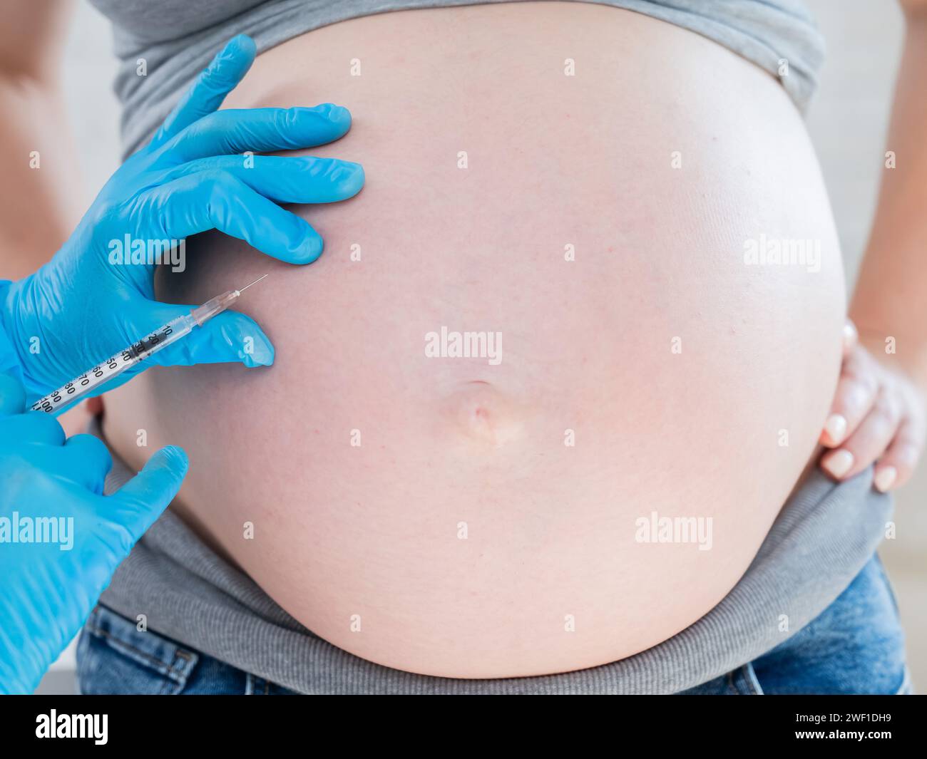 Doctor gives an injection in the stomach of a pregnant woman Stock