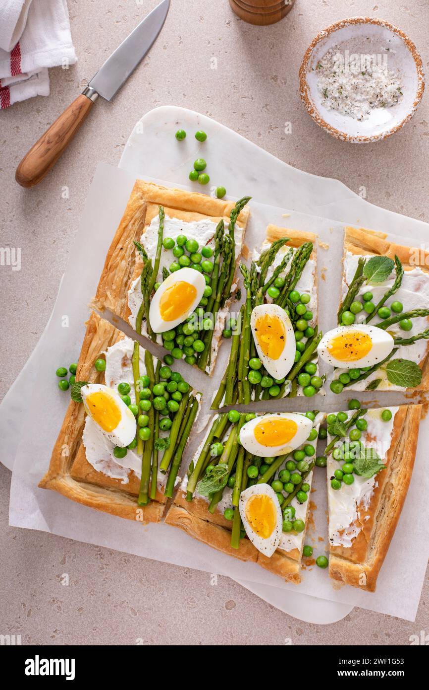 Asparagus and egg tart with peas, puff pastry and cream cheese, spring