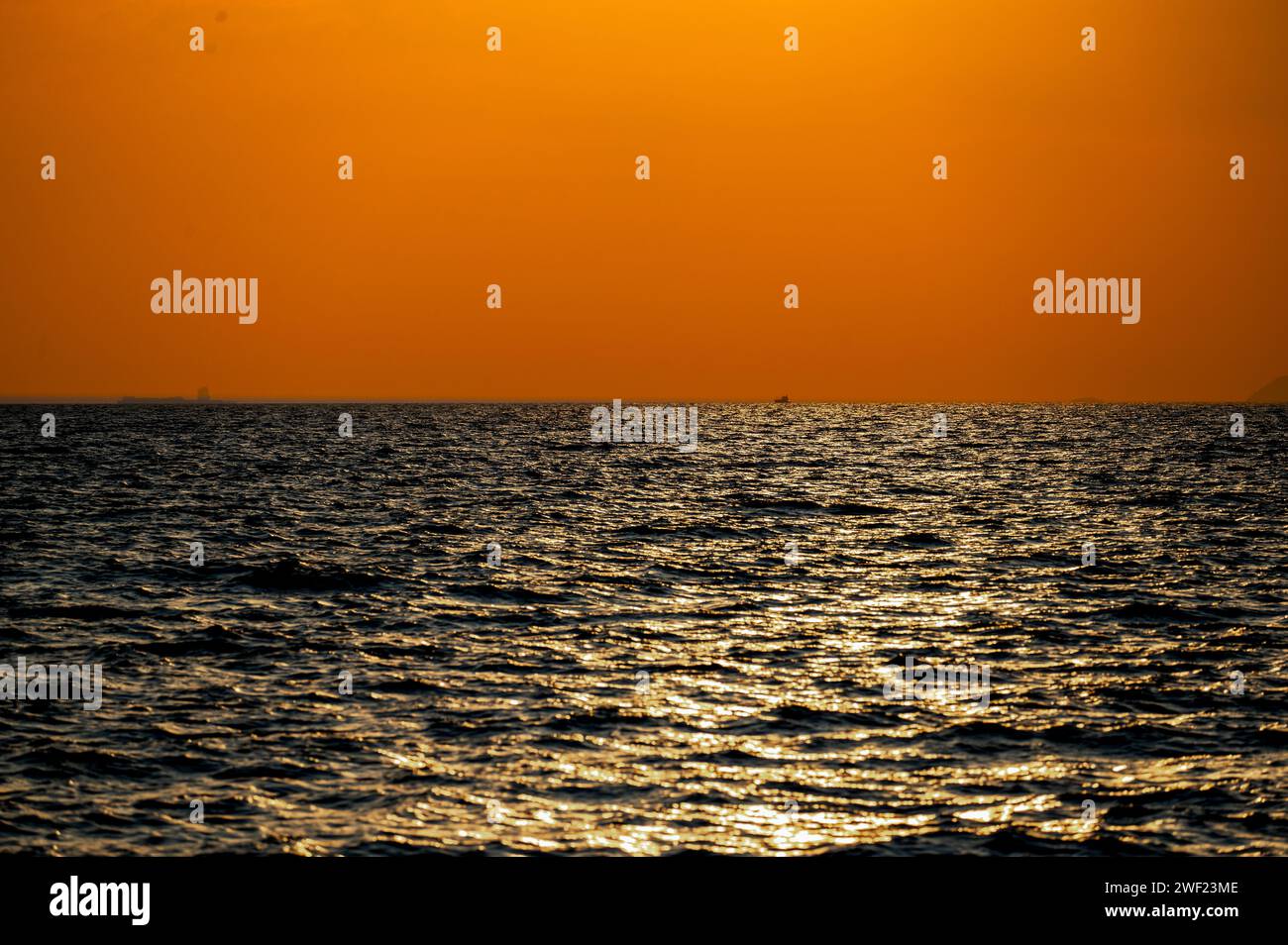 fiery sunset over ocean, with vibrant shades of orange and red painting ...