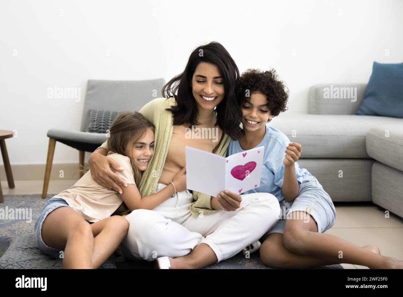 Happy Latin mom hugging adorable son and daughter with love Stock Photo ...