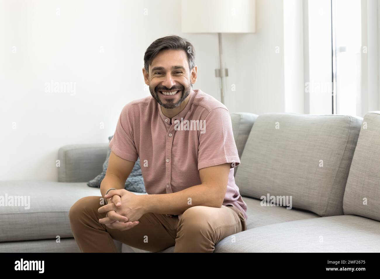 Happy handsome middle aged man sitting on comfortable sofa Stock Photo
