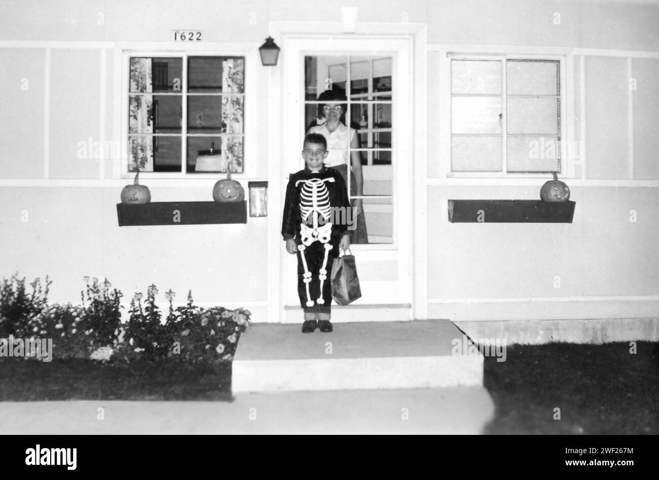 A young boy dressed in a skeleton costume is ready for Halloween, ca