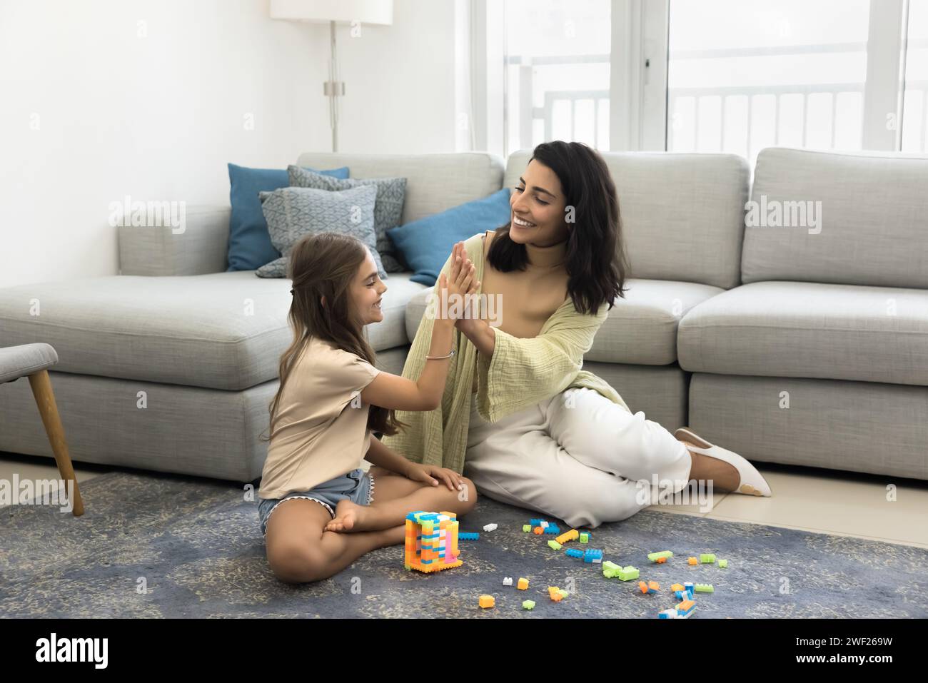 Joyful Latin mom and cheerful daughter girl giving high five Stock ...
