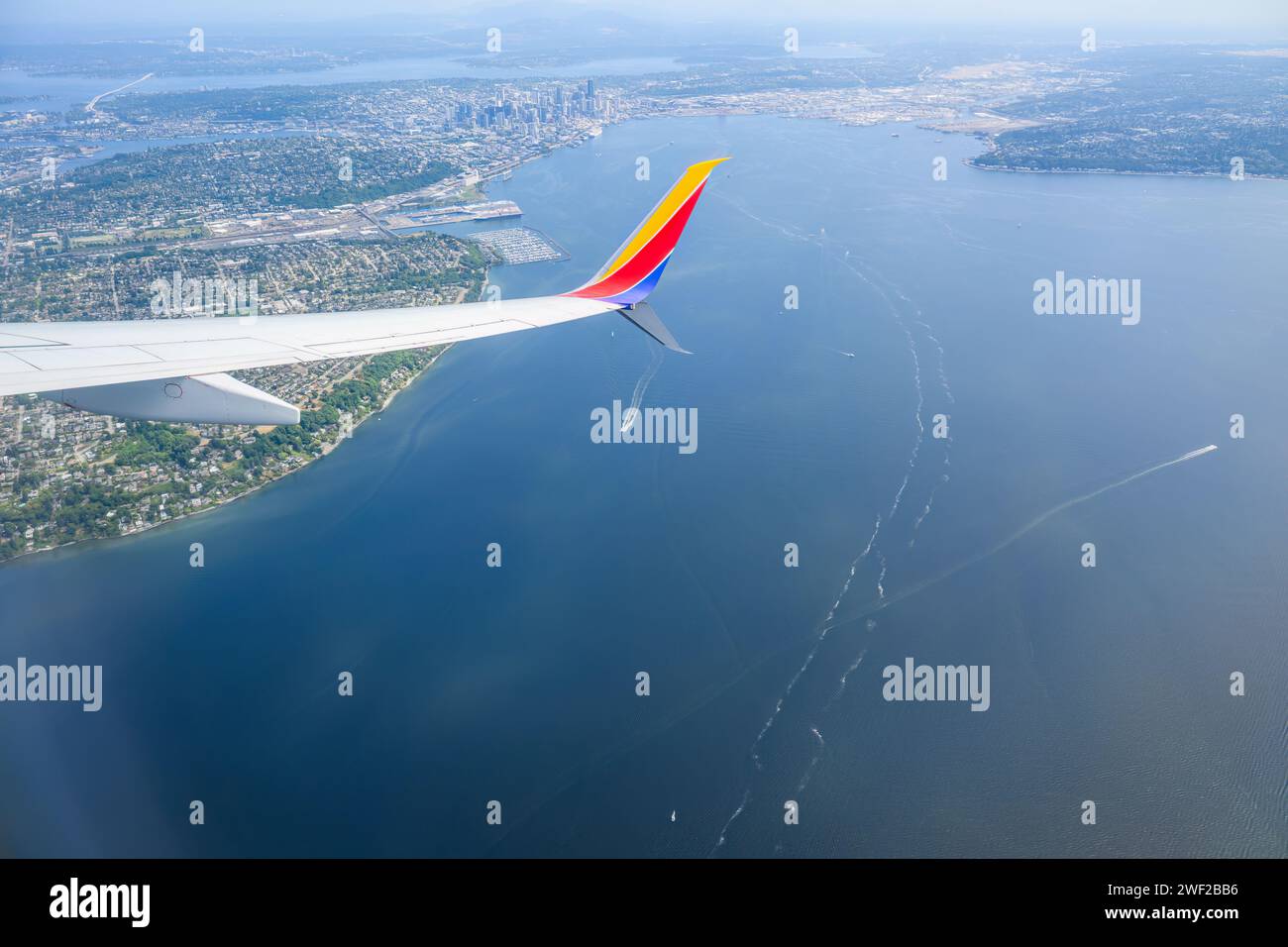 Seattle, USA - Jul 30 2023: Southwest Airlines airplane flying towards Seattle. Aerial view of Seattle cityscape. Stock Photo