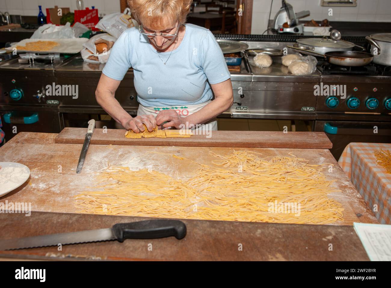 perugia Italy - May 14 2011; Handling the cut folded dough for traditional pasta making. Stock Photo