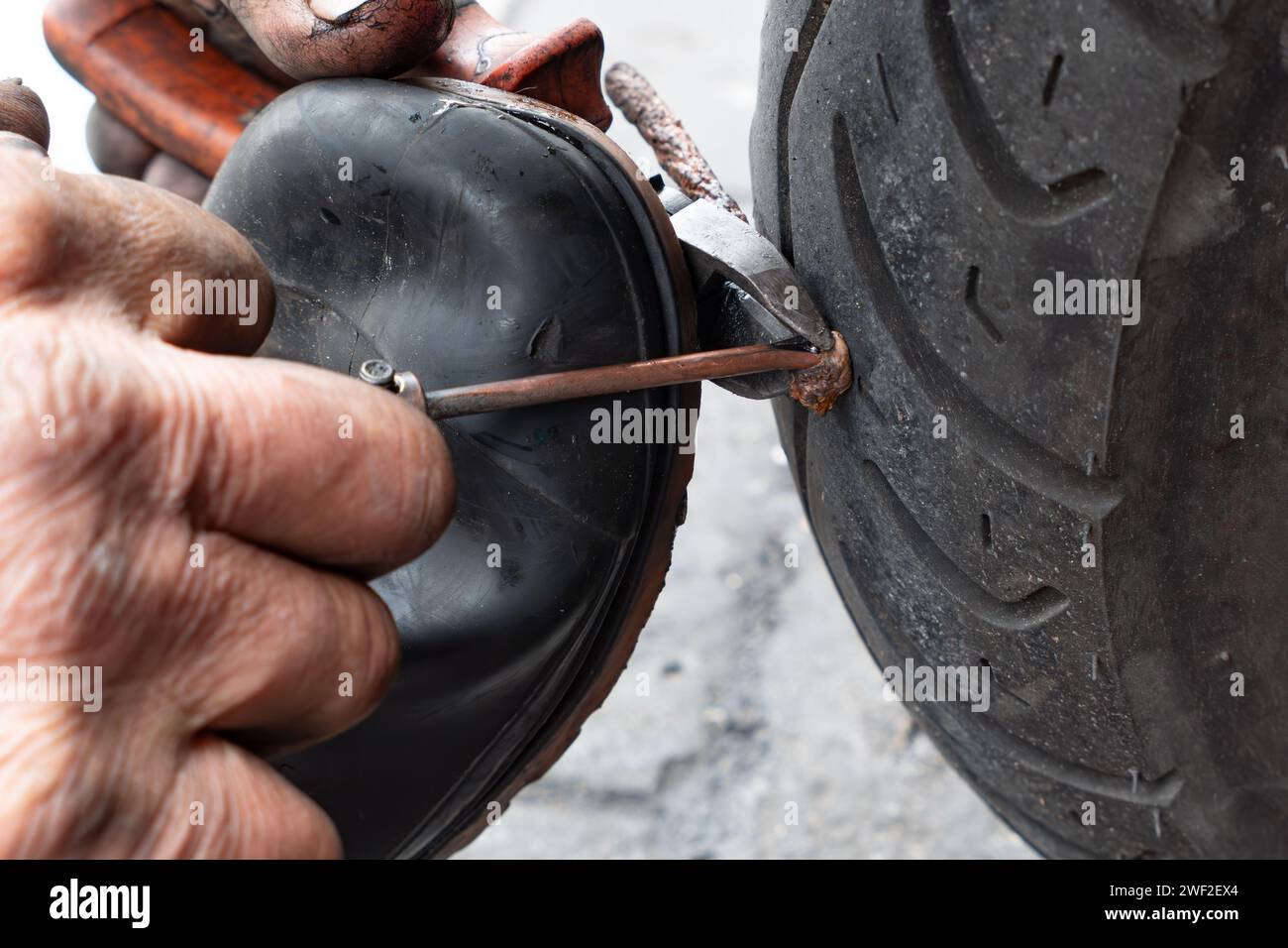 a professional repairman installing a patch and fixing a tire Stock Photo
