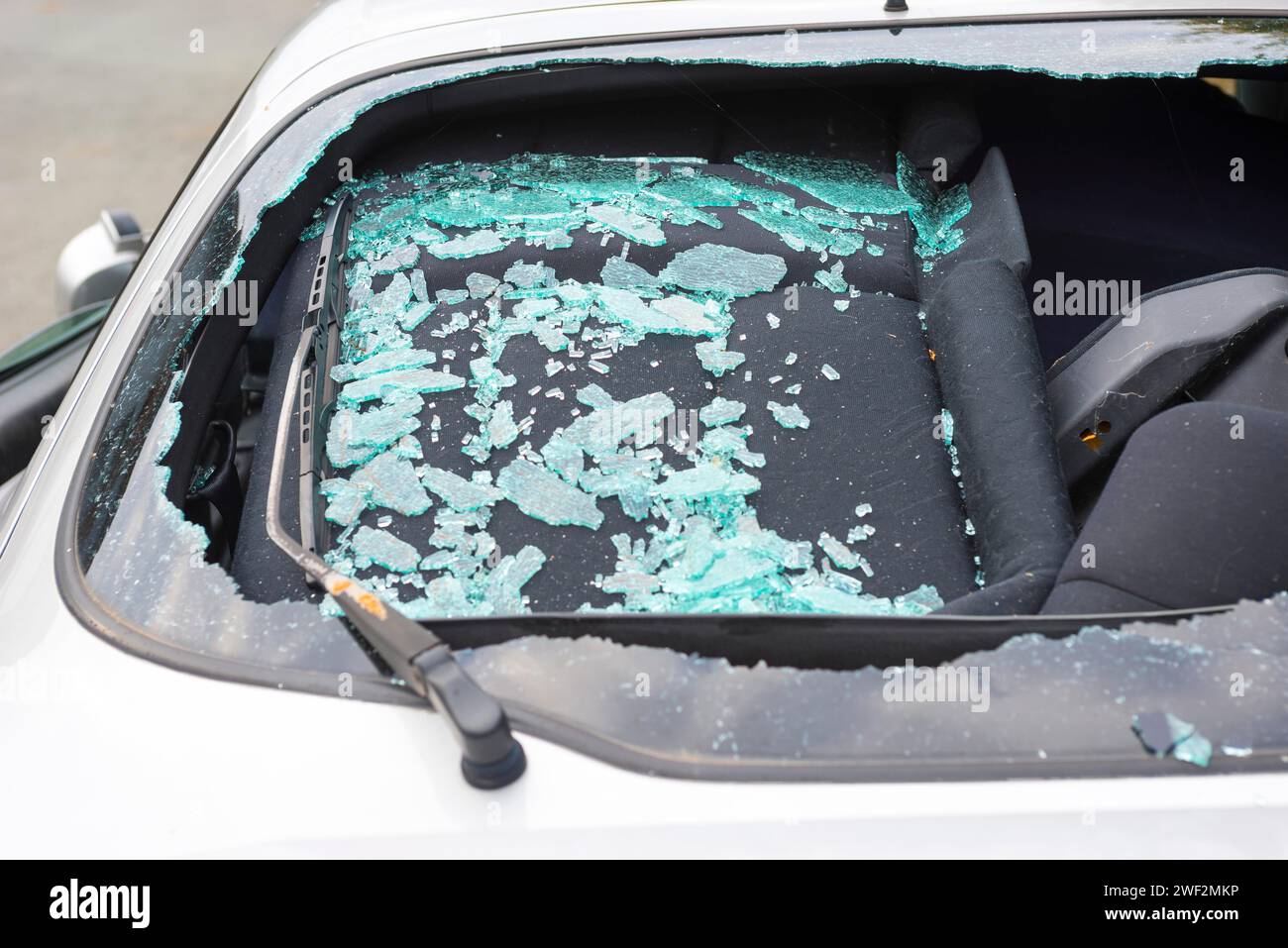 Accident car, sporty car with accident damage standing on a road, broken rear view window of a car with a view of the damaged interior, broken safety Stock Photo