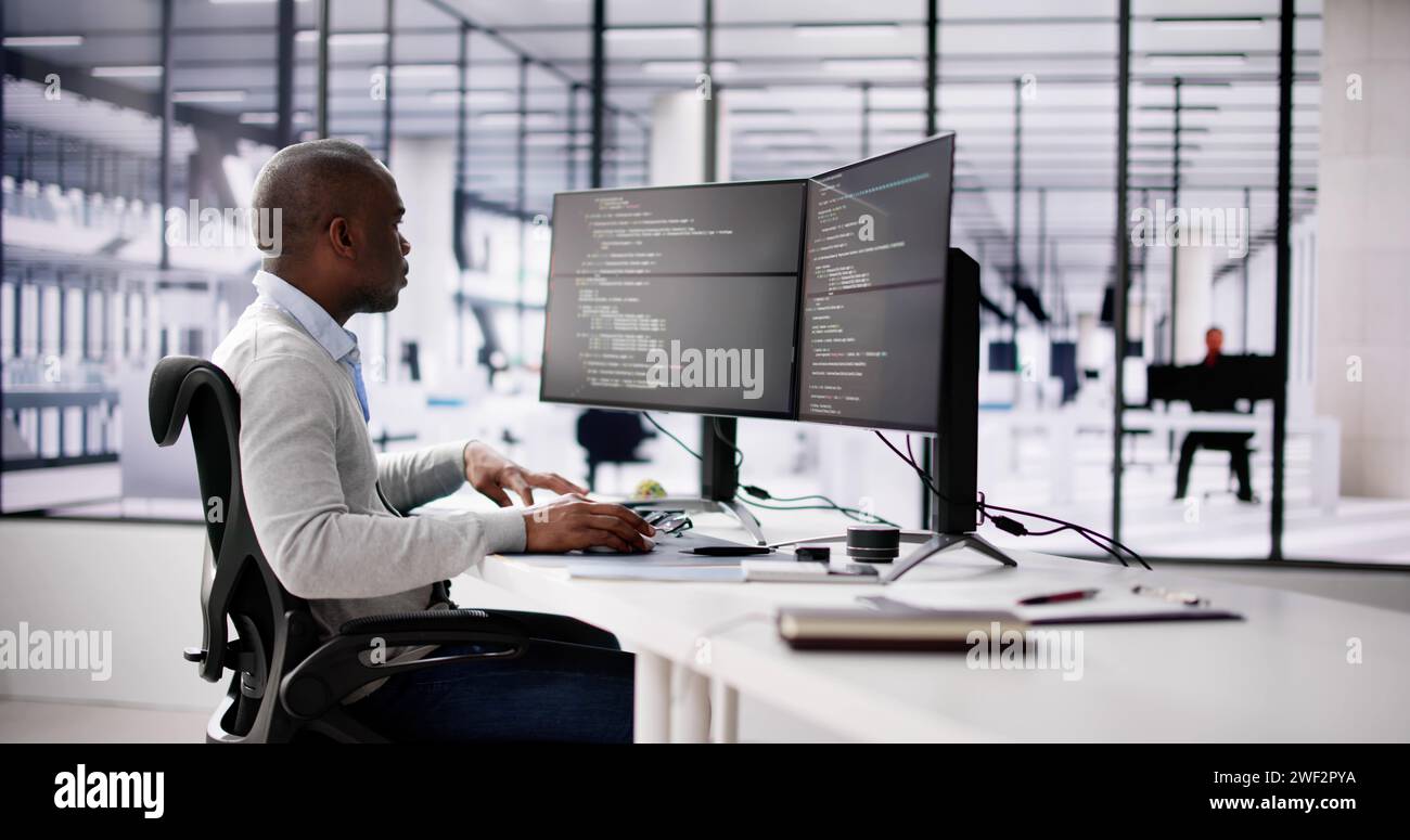 African American Coder Using Computer At Desk. Web Developer Stock Photo