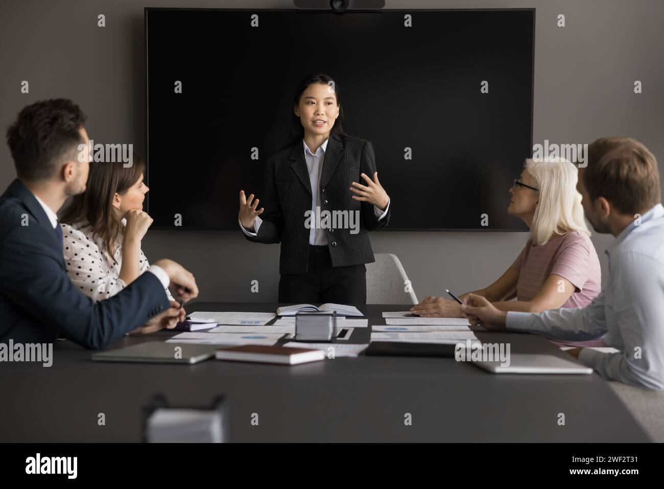 Engaged young Asian project manager presenting startup to coworkers Stock Photo