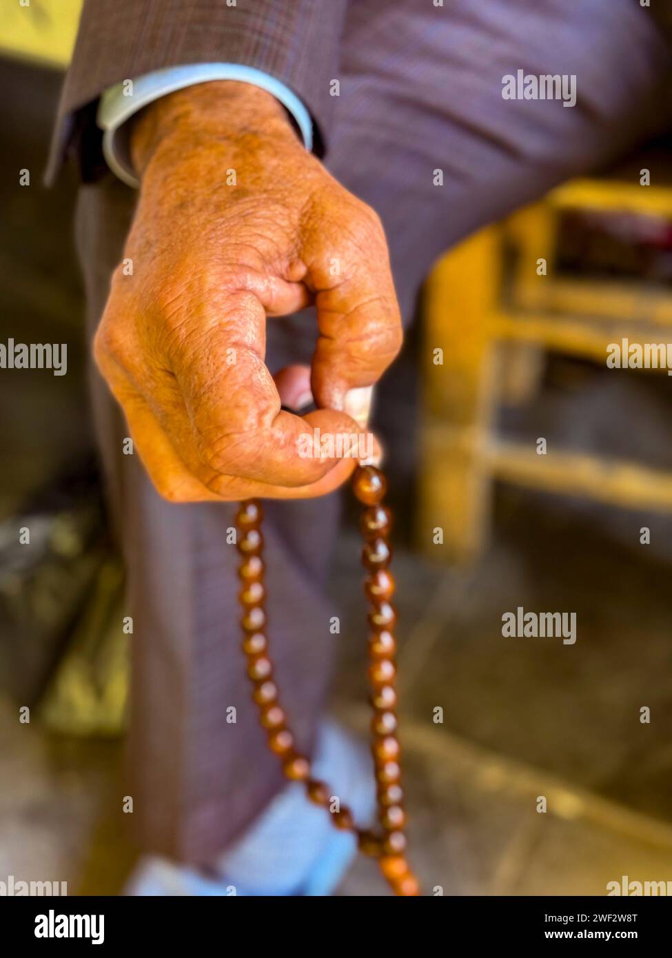 Closeup of hand holding prayer beads. Stock Photo