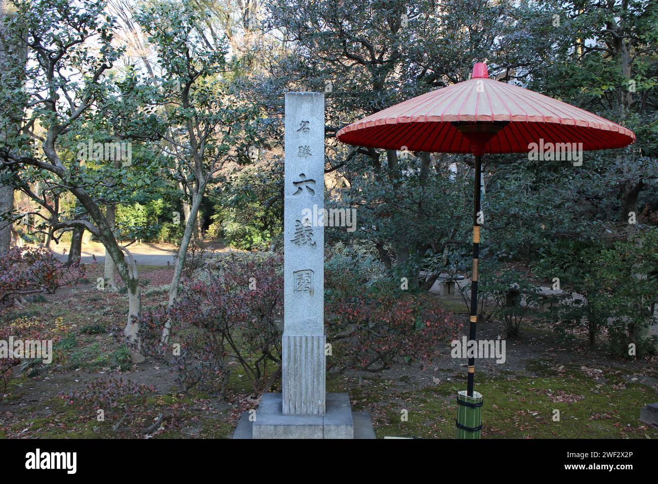Stone monument and traditional umbrella in Rikugien Garden, Tokyo, Japan (Japanese words mean the name of garden 'Rikugien') Stock Photo