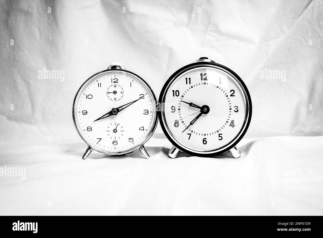 Two retro alarm clocks in black and white on white background Stock Photo