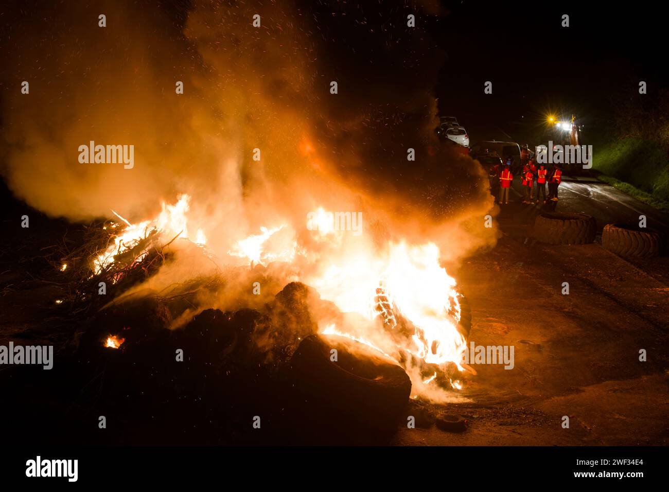 © PHOTOPQR/OUEST FRANCE/Thierry Creux ; Kervignac ; 27/01/2024 ; Kervignac. Morbihan . Les agriculteurs dit asyndicaux devaient lever le barrage de Kervignac sur la RN165 entre Lorient et Auray, à l'intersection de la RN24. Finalement ils l'ont maintenu. Autour de 19h30, ils étaient nombreux sur le site etentretenaient un feu géant riche en fumées noires, tout en maintenant un passage des deux côtés pour les besoins des secours . (Photo Thierry Creux/Ouest-France) Hennebont; 01/27/2024; Hennebont. Morbihan. A cohort of tractors arrived at the end of the afternoon at Leclerc where a delega Stock Photo