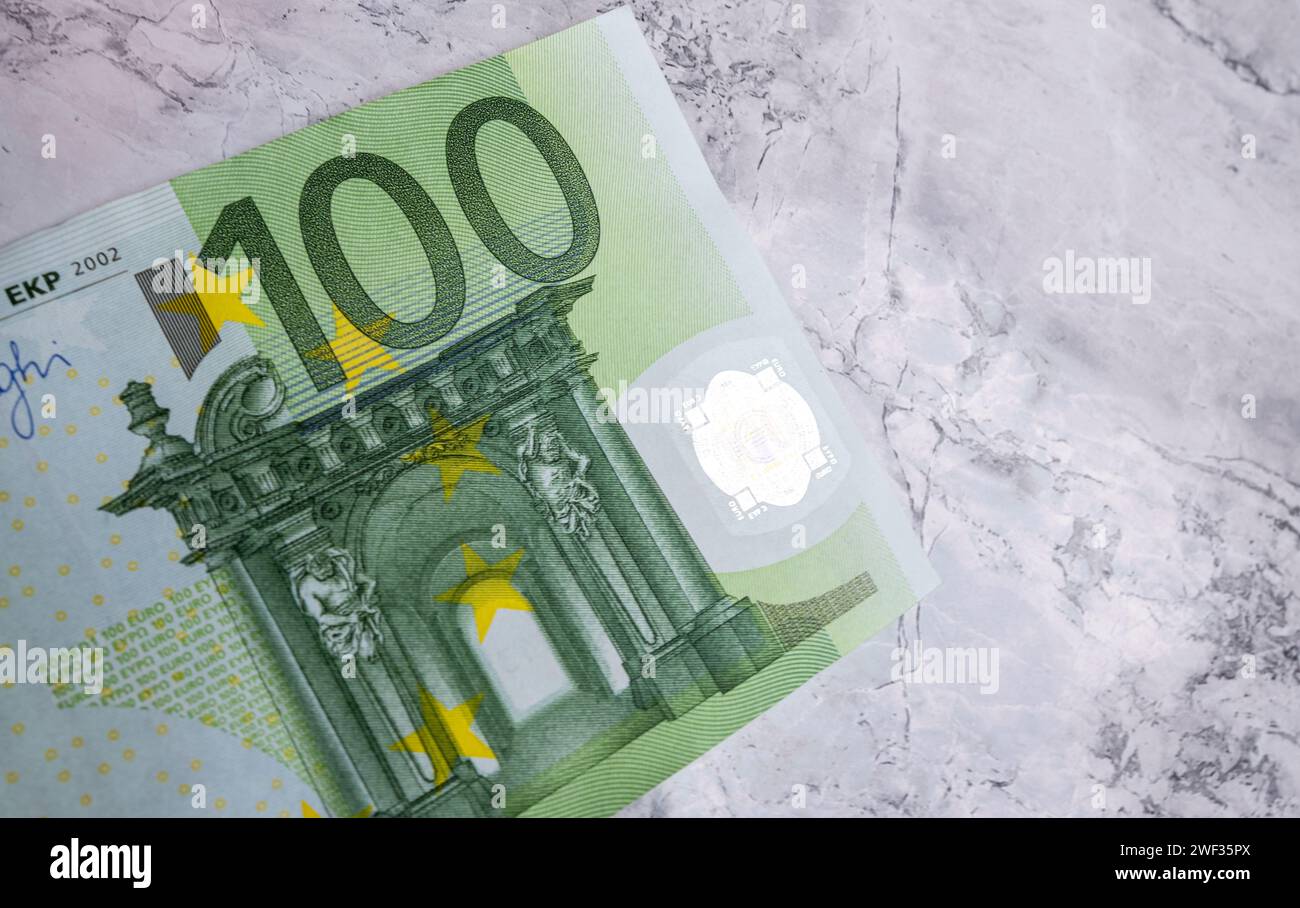Close-up high quality photo of a 100 Euro banknote isolated on the background. Euro banknotes, inflation and price increases. Savings and investme Stock Photo