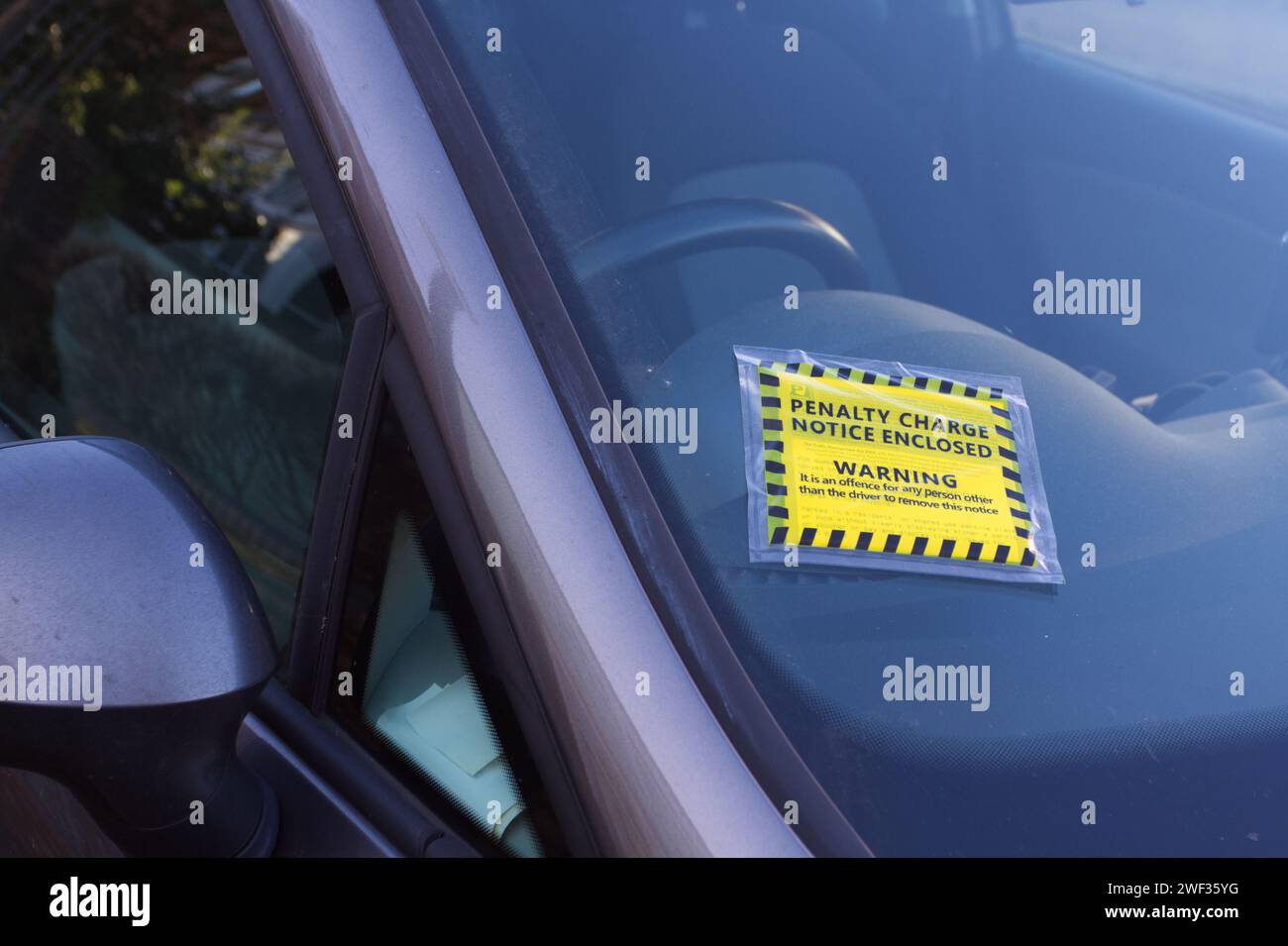 Penalty charge notice, PCN, enclosed warning stuck on a car windscreen. Stock Photo