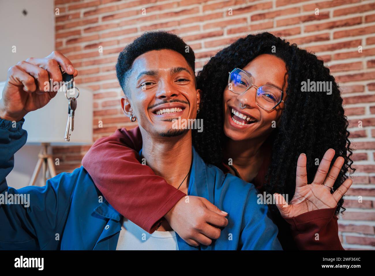 Young african american couple showing keys of their first house after ...