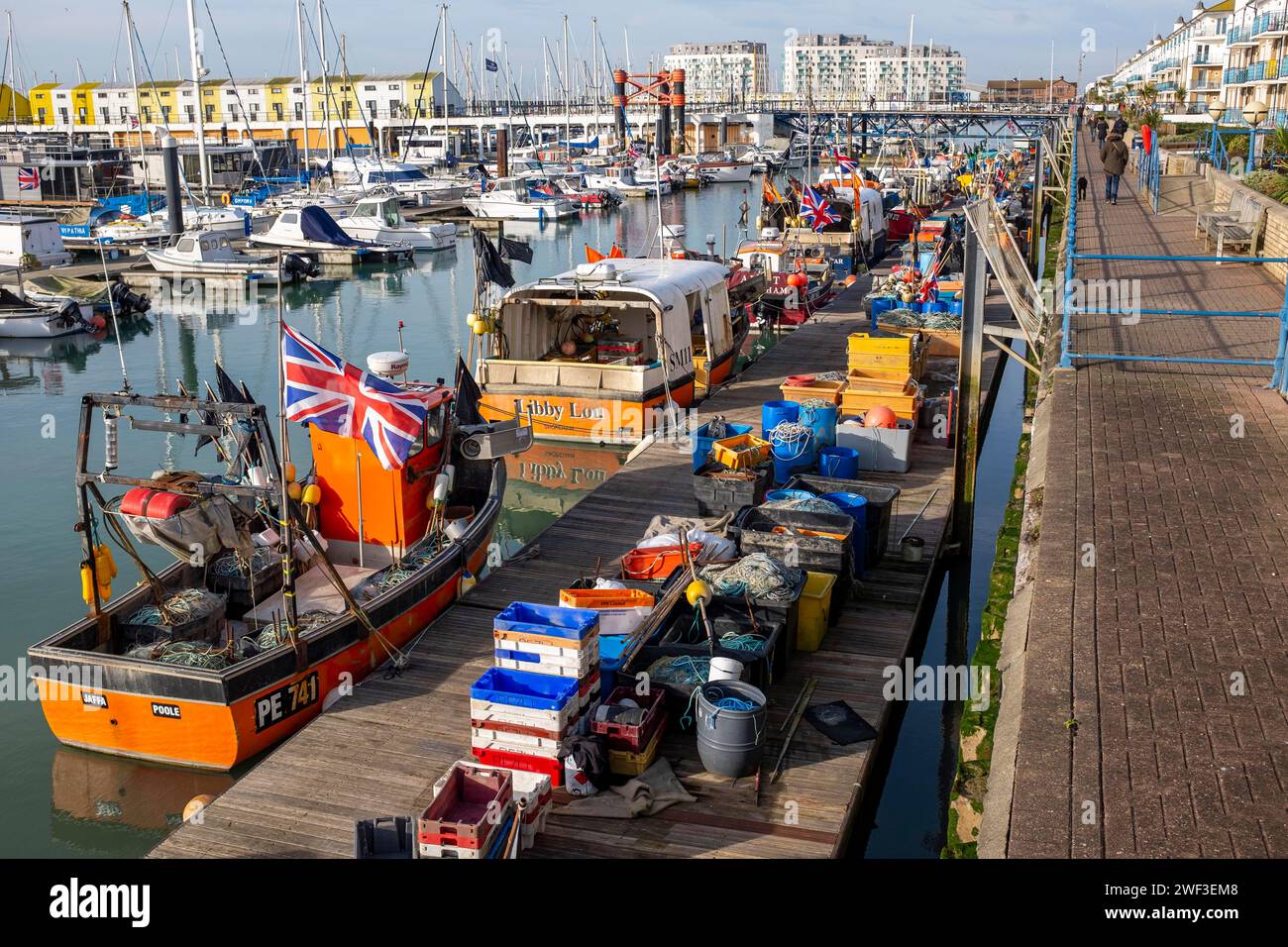Brighton UK 28th January 2024 -  Fishing boats with Union Jack flags  moored in the winter sun at Brighton Marina as much more mild weather than of recent days is forecast for most of Britain today : Credit Simon Dack / Alamy Live News Stock Photo