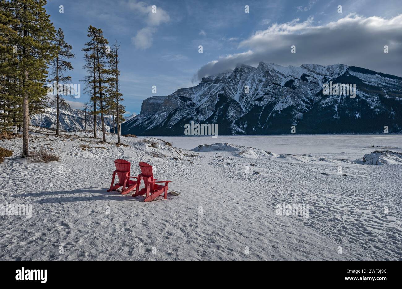 Winter view of red chairs at frozen Lake Minnewanka in Banff National Park, Alberta, Canada Stock Photo