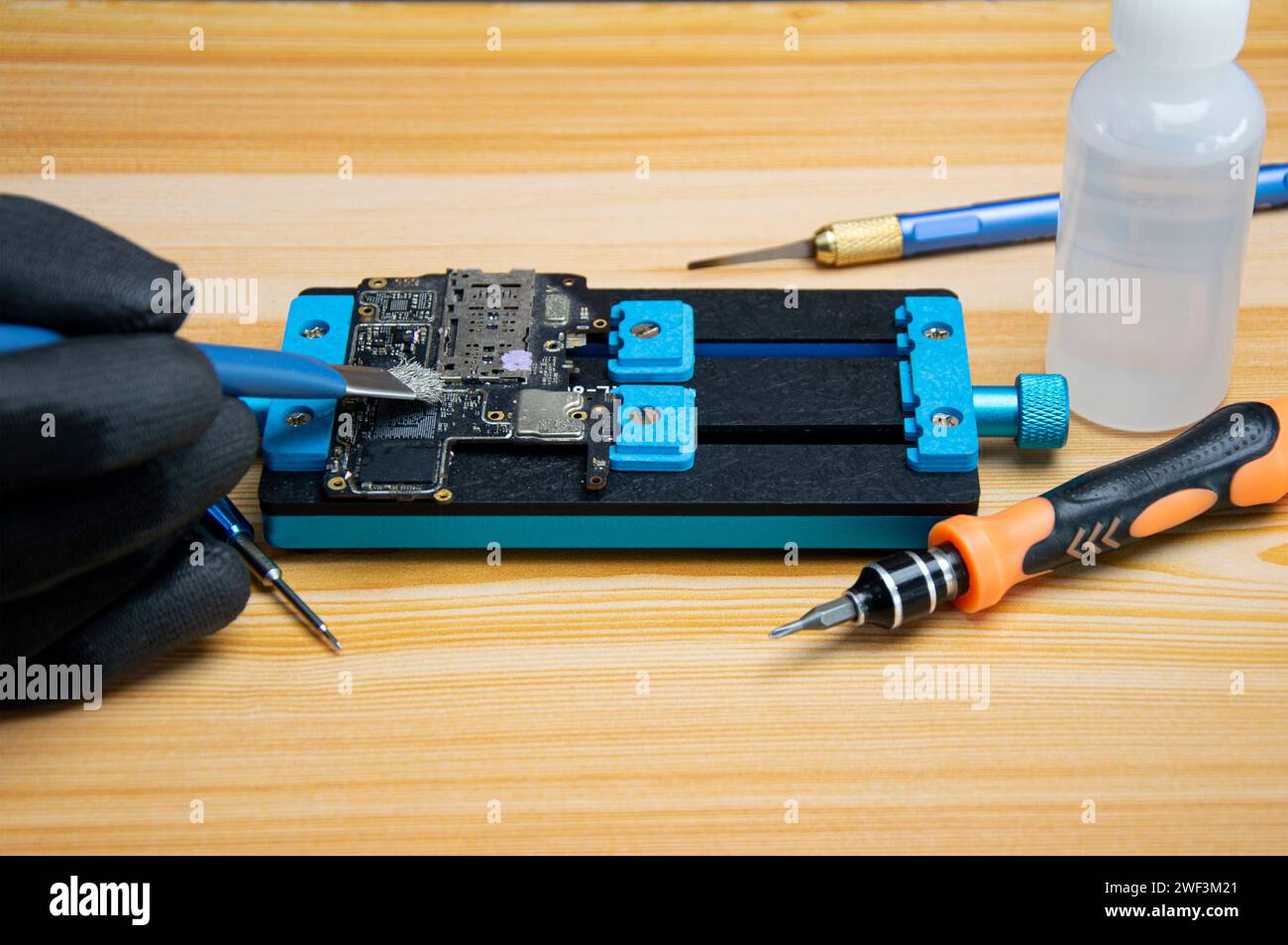 Technician is repairing Smartphone motherboard, circuit repair Stock