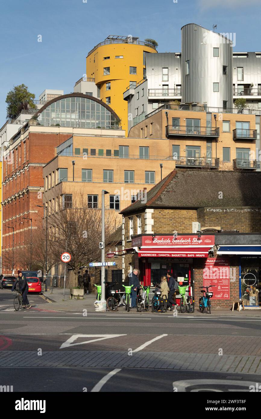 Southwark street scene in Bankside London SE1 with a sandwich shop, cyclists, and colourful modern architecture of Bankside Loft in the background Stock Photo