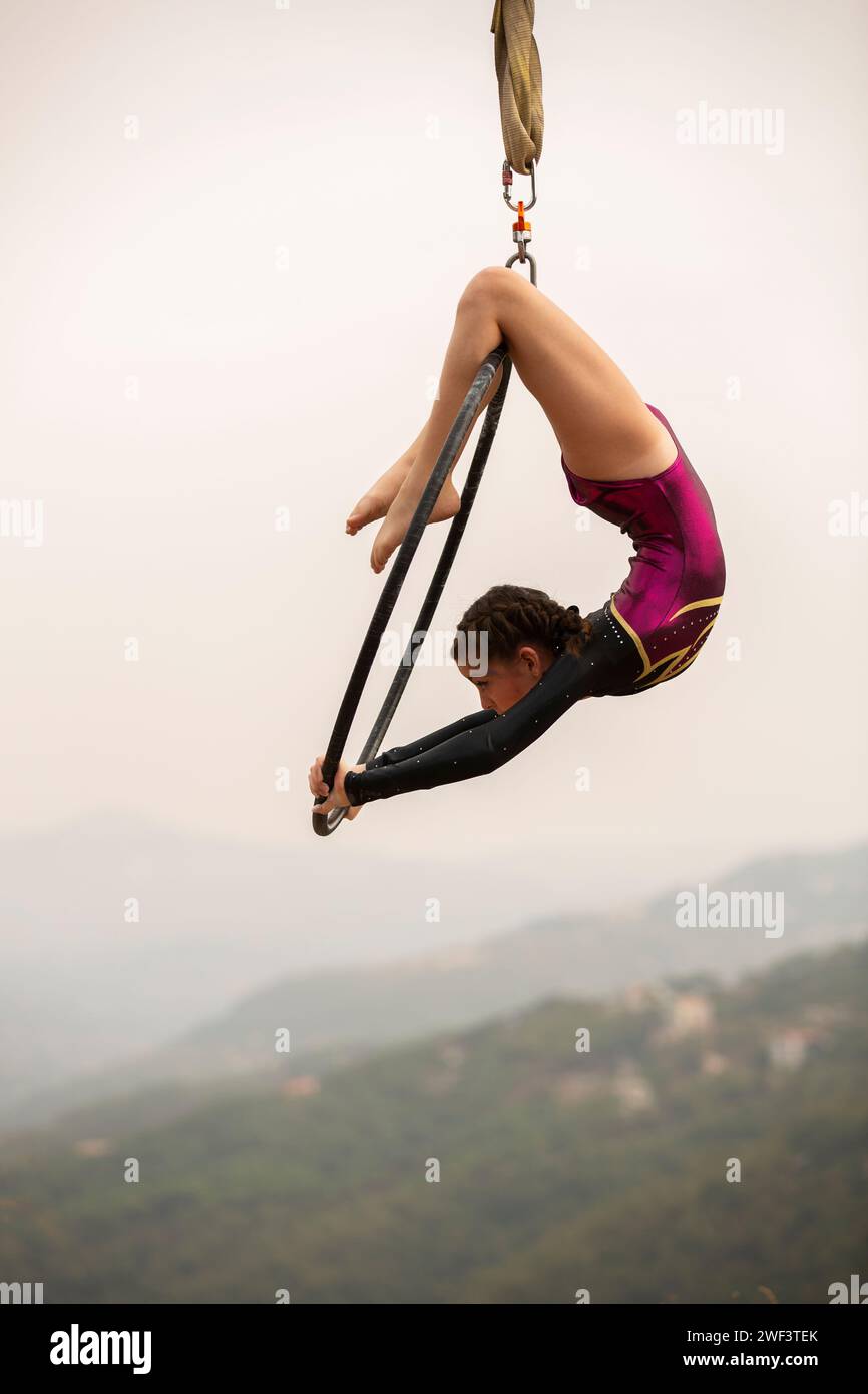 12 years old girl gymnast performing on aerial hoop outdoors Stock Photo