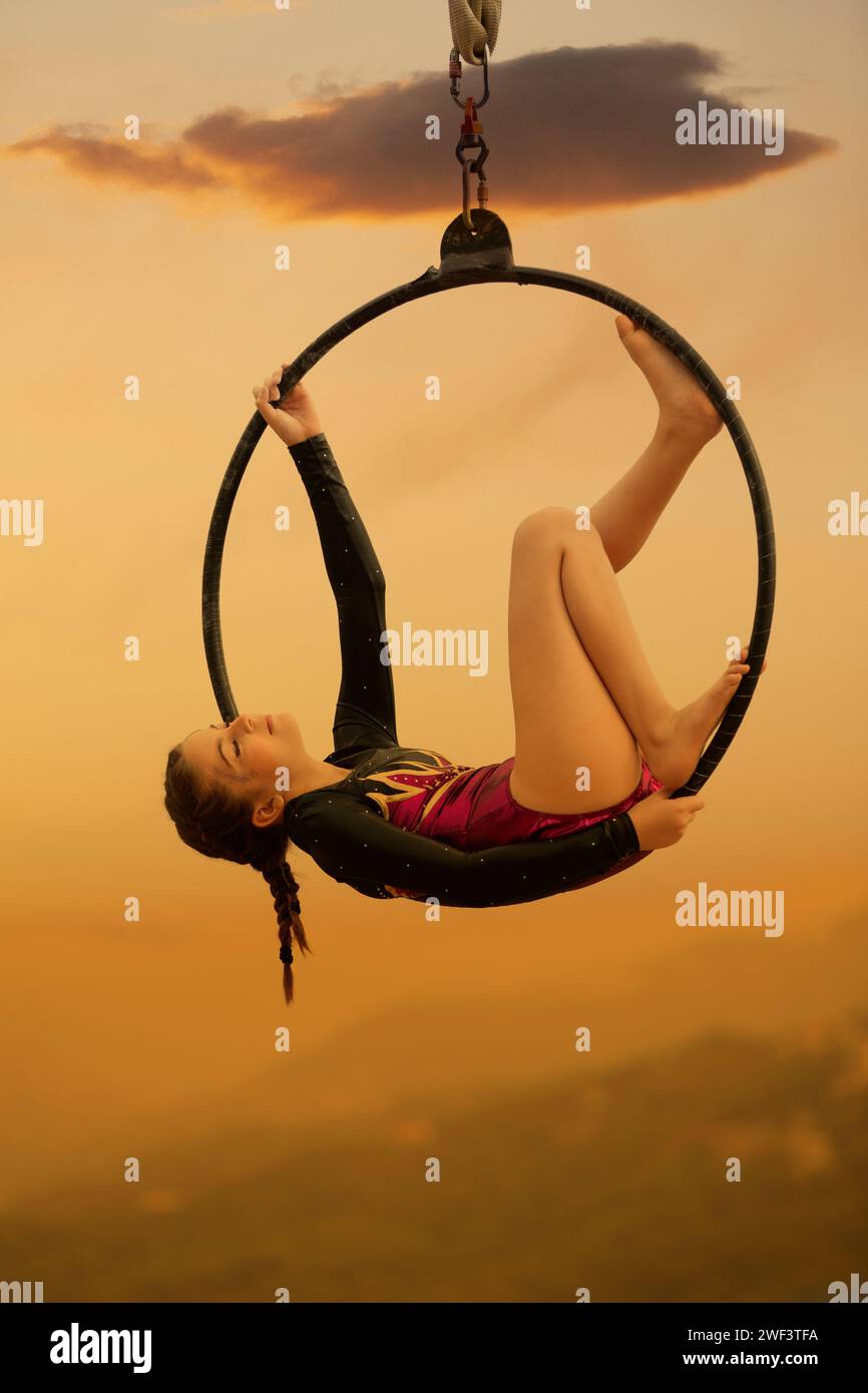 12 years old girl gymnast performing on aerial hoop outdoors Stock Photo