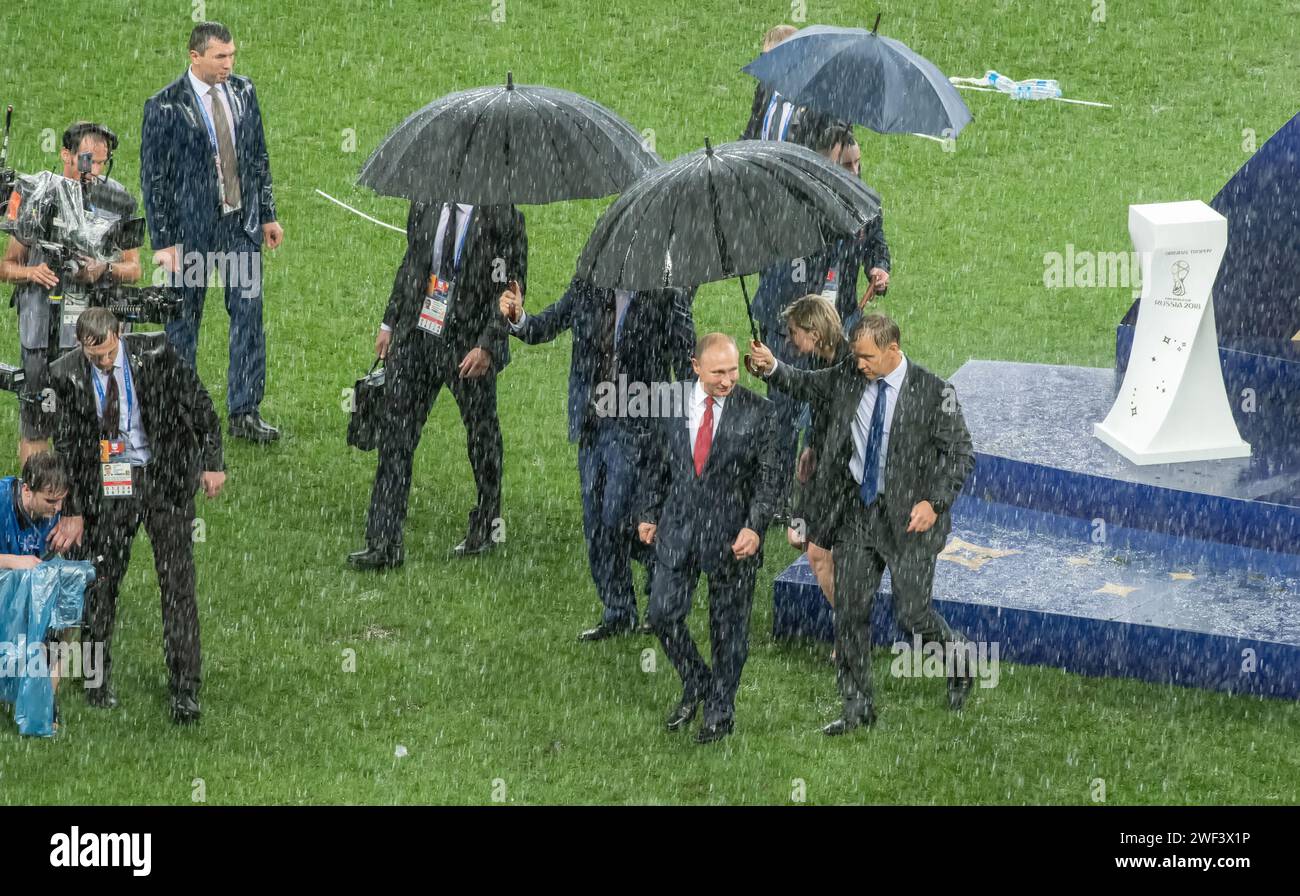 Moscow, Russia – July 15, 2018. Russian President Vladimir Putin escorted from the pitch in the pouring rain after the trophy award ceremony of the Wo Stock Photo
