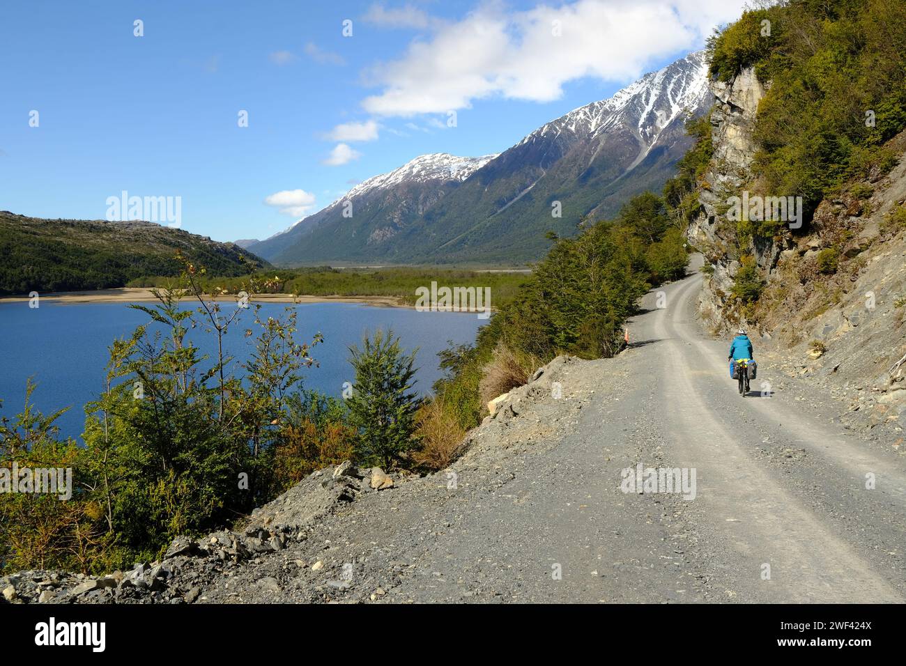 A cyclist rides along the wild southern section of the Carretera Austral next to Lago Vargas near Villa O'Higgins. Stock Photo