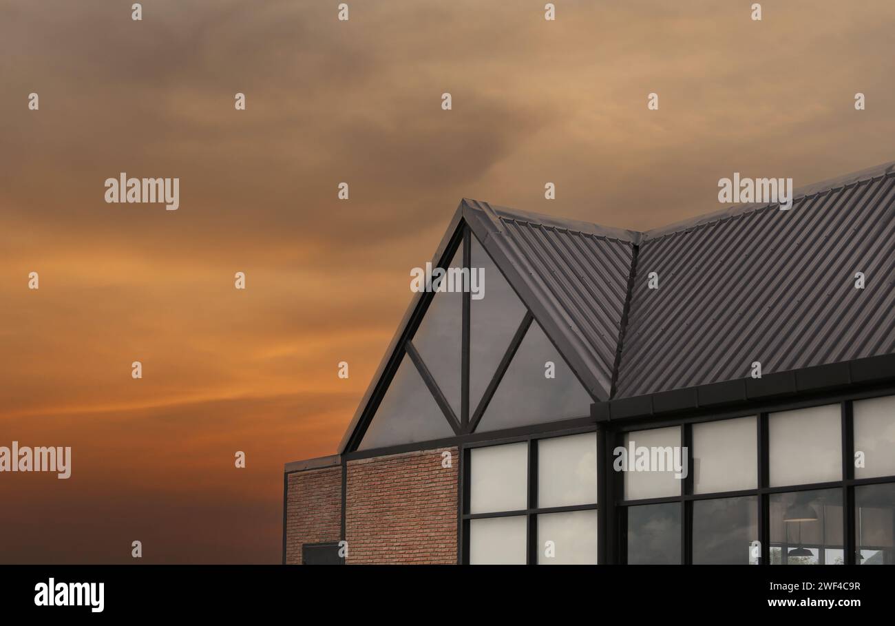Modern house roof on sunset sky background for design in your work. Stock Photo