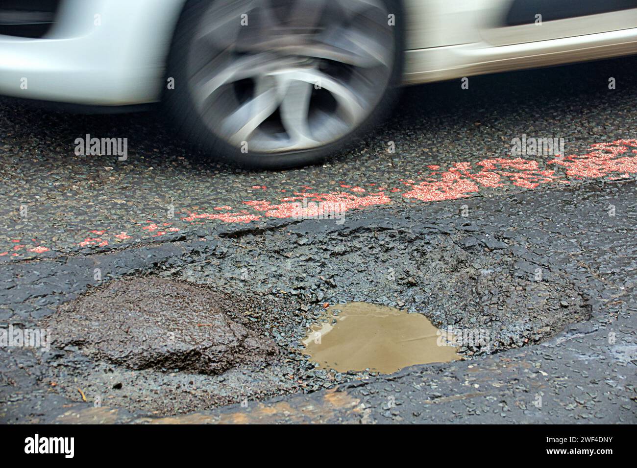 Glasgow, Scotland, UK.  23rd January, 2024. UK Weather: Miserable day reflected in the dystopian streets as locals struggle in a decaying environment.  City roads riddled with potholes despite constant protest. Credit Gerard Ferry/Alamy Live News Stock Photo